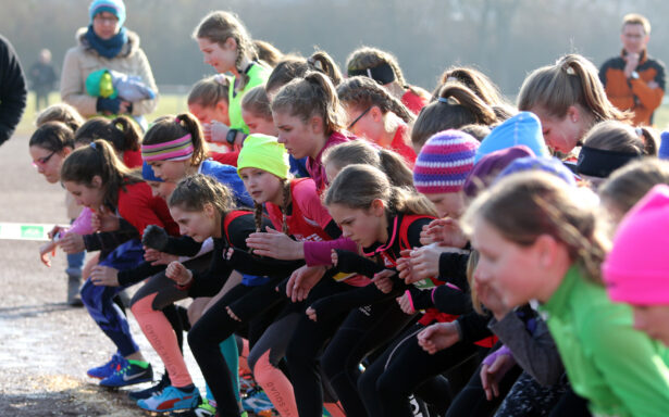 Junge Athletinnen stehen an der Startlinie und warten auf das Startsignal.